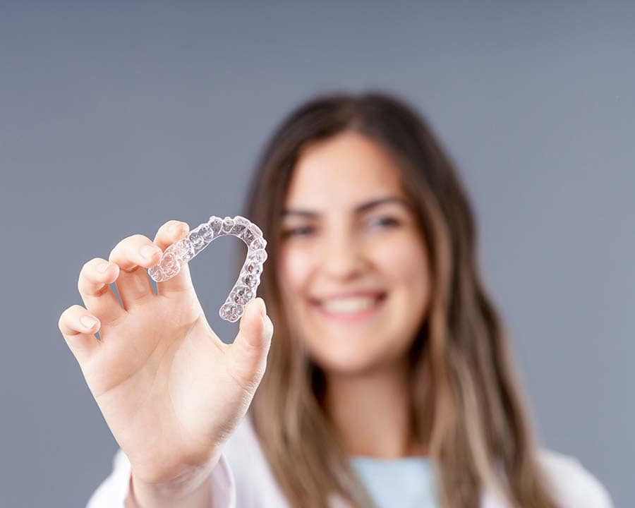 Client holding clear Invisalign trays