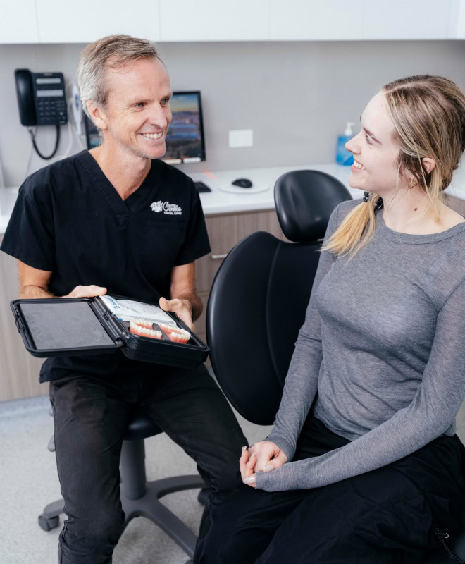 Dentist explaining dental procedure to patient.