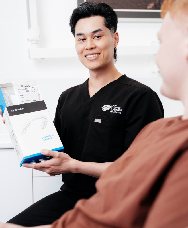 Dentist showing Invisalign package to patient.