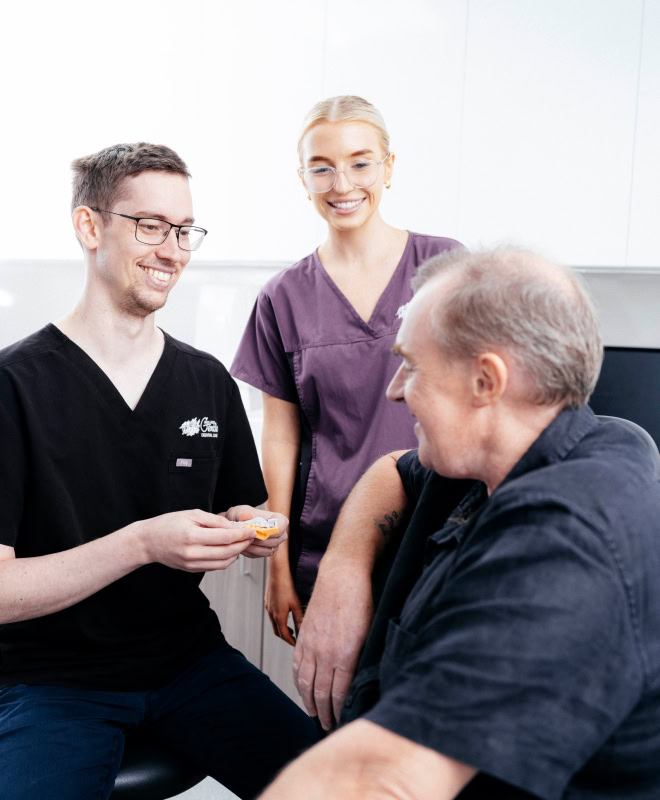 Dentists consult patient in clinic setting.