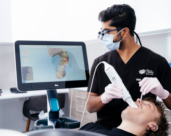 Dentist using digital scanner on patient