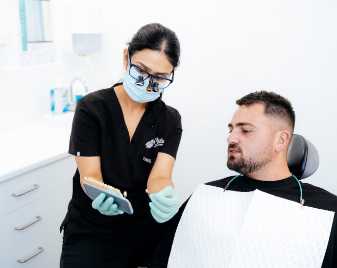 Dentist showing patient a tooth shade guide.