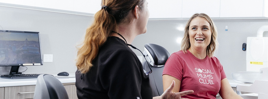 Two women chatting at dental clinic.