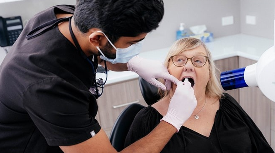 A Victoria Point dentist examines a patient's mouth in a dental surgery.