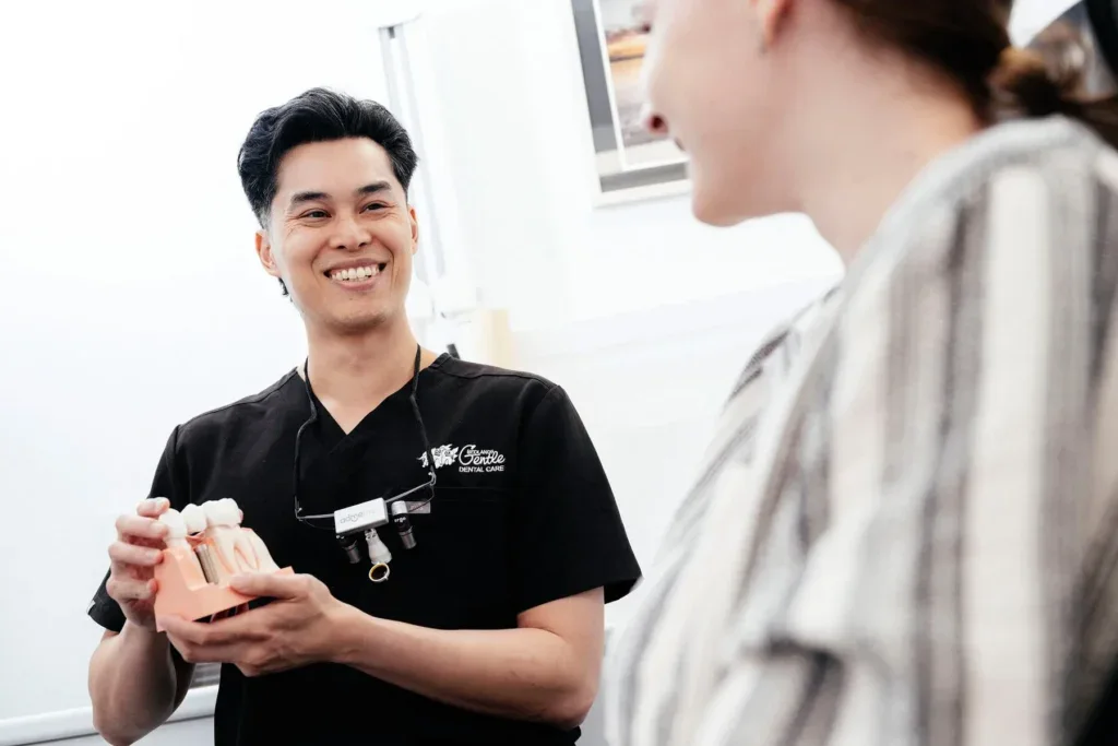 Dentist explaining dental model to patient.