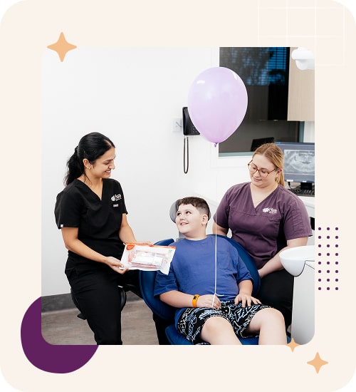 Child with dental staff holding a balloon.