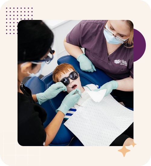 Child receiving dental check-up from professionals.