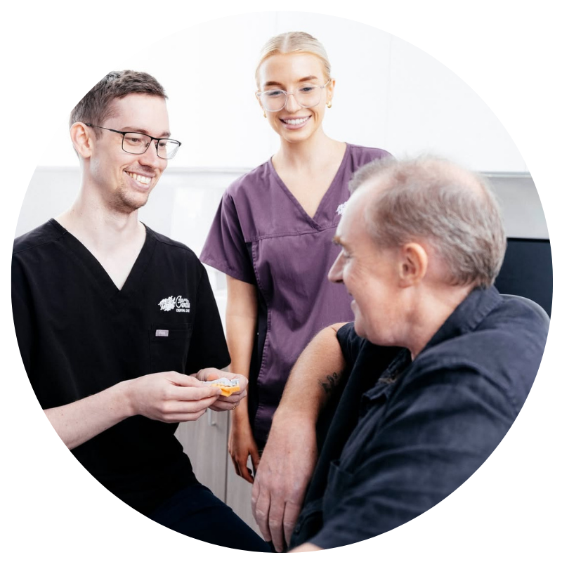 Dental professionals consult with patient in clinic.