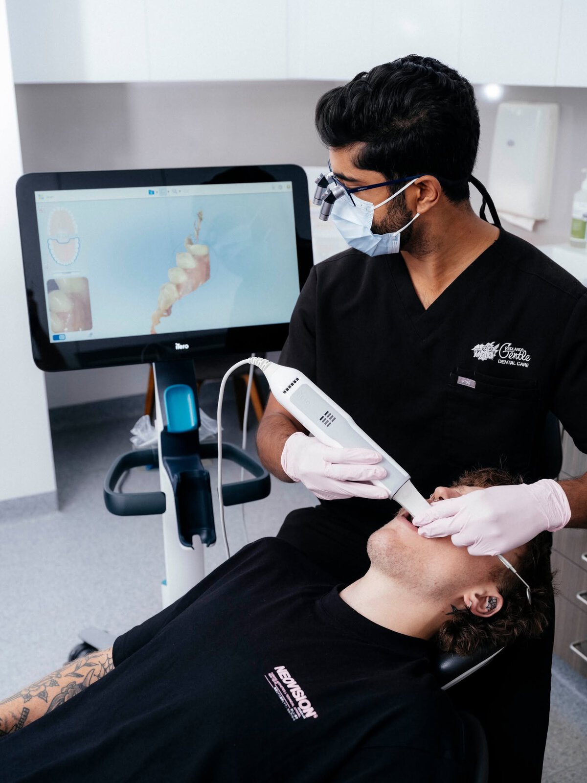 Dentist scanning patient's teeth with digital scanner.